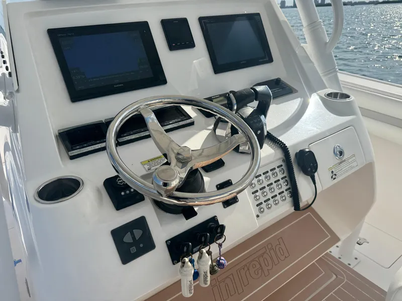 Slide: The Image of Helm of 2016 Intrepid 375 CC boat with steering wheel and navigation screens. - 12
