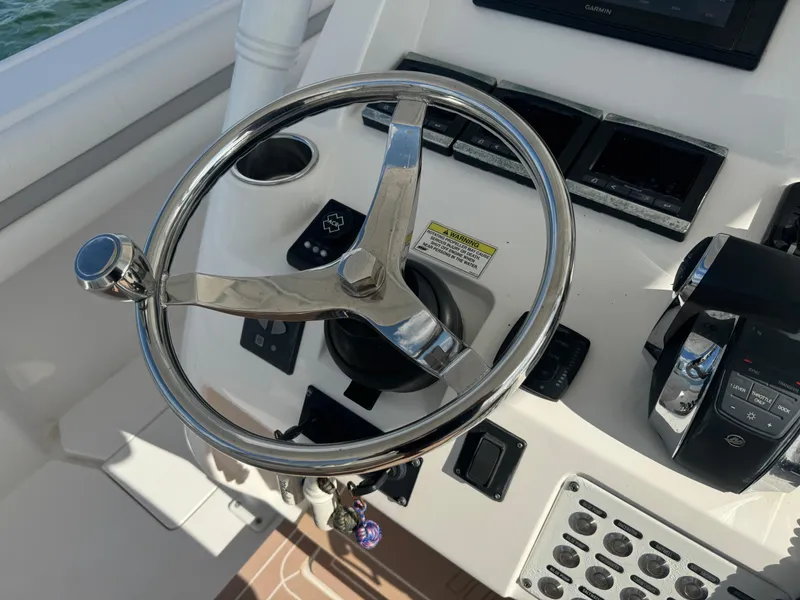 Slide: The Image of Steering wheel and controls of a 2016 Intrepid 375 CC boat cockpit. - 13