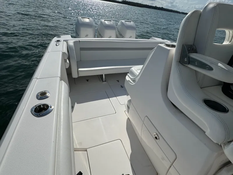 Slide: The Image of 2016 Intrepid 375 CC boat interior with seating and triple outboard engines on water. - 26