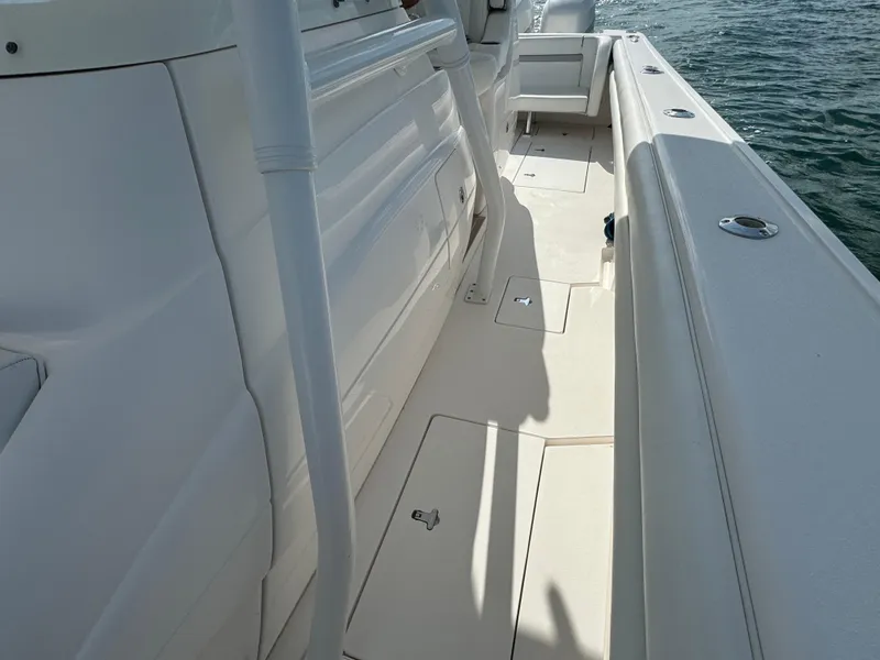 Slide: The Image of 2016 Intrepid 375 CC boat deck with white seating and storage compartments. - 27