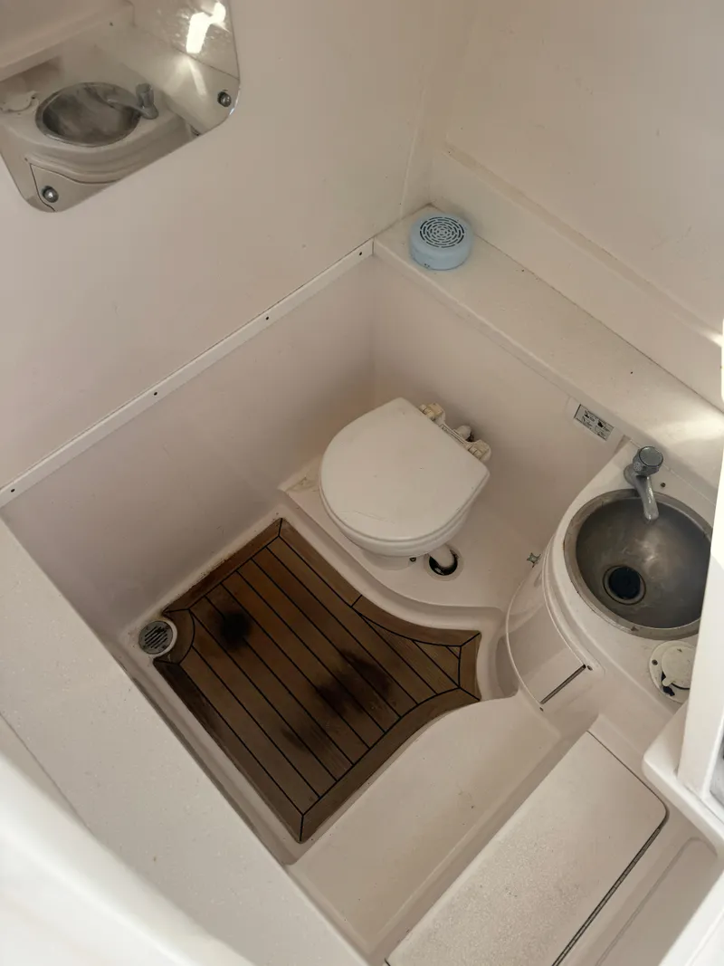 Slide: The Image of 2016 Intrepid 375 CC boat bathroom with toilet, sink, and wooden floor mat. - 34