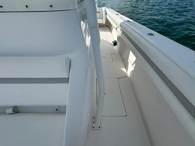 Slide: The Image of 2016 Intrepid 375 CC boat deck with white seating and railing, on calm water. - 35