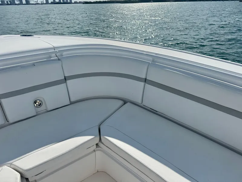 Slide: The Image of 2016 Intrepid 375 CC boat with cushioned seating, overlooking calm water and distant city skyline. - 44