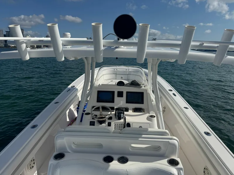 Slide: The Image of 2016 Intrepid 375 CC boat with modern helm, dual screens, and rod holders on open water. - 6