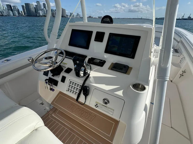 Slide: The Image of 2016 Intrepid 375 CC boat dashboard with steering wheel, controls, and navigation screens. - 9