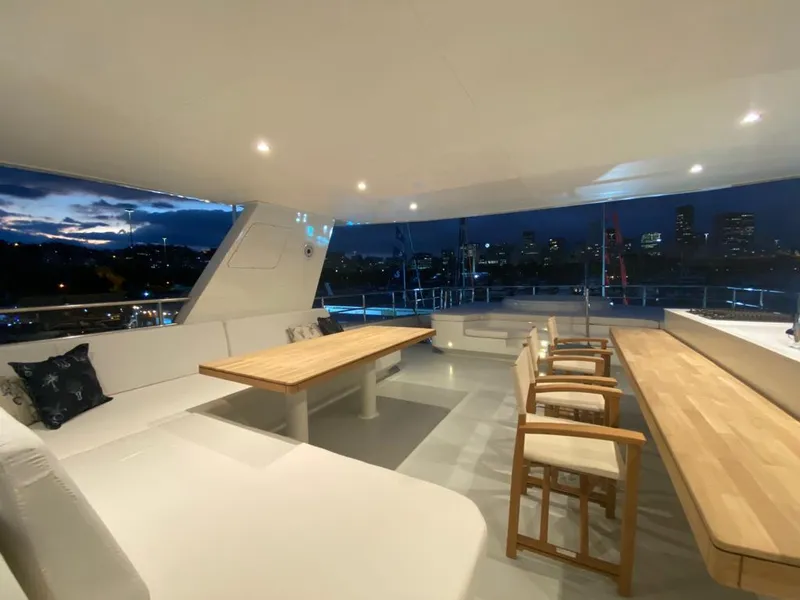 Slide: The Image of Luxurious Inace Explora 90 yacht interior, featuring elegant seating and dining area, city skyline view. - 4