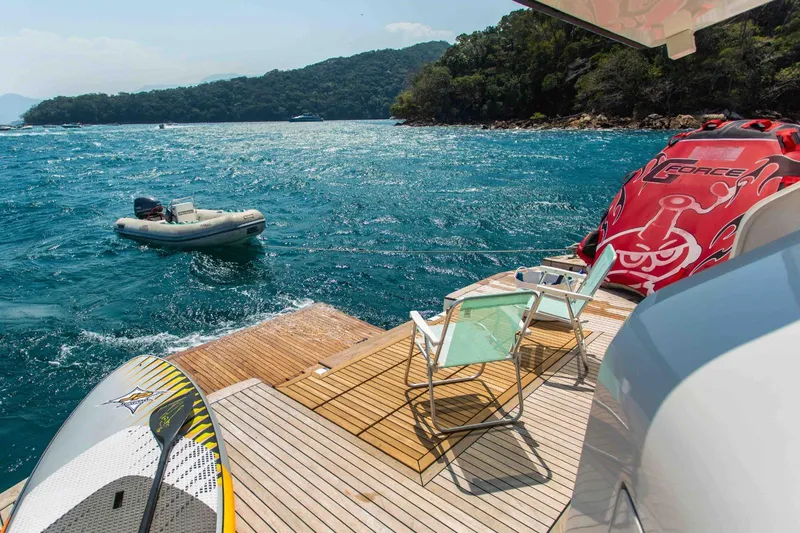 Slide: The Image of Luxury yacht deck with chairs, paddleboard, and inflatable boat on turquoise water. Inace Explora 90, 2027. - 8