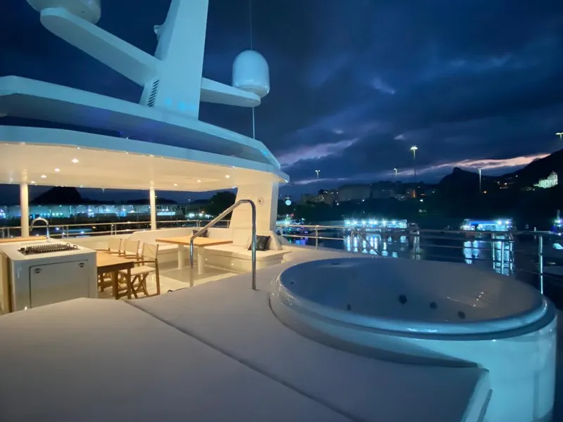 Slide: The Image of Luxurious Inace Explora 90 yacht deck with jacuzzi, illuminated at night, 2027 model. - 3