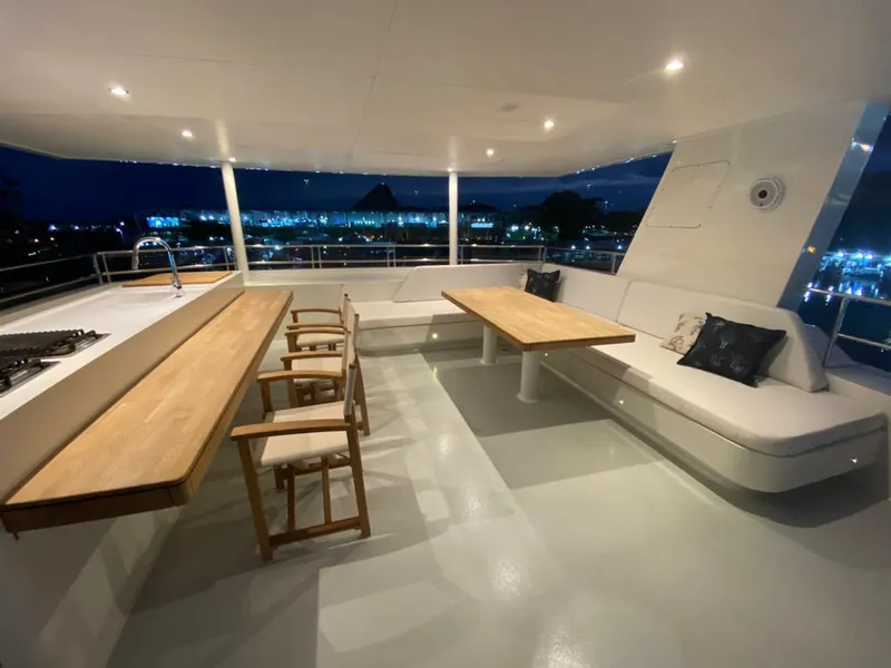 Slide: The Image of Luxurious 2027 Inace Explora 90 yacht deck with seating and dining area at night. - 5