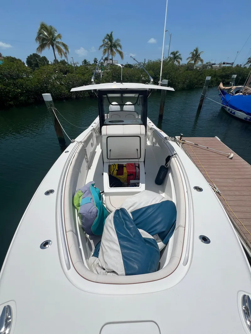 Slide: The Image of 2022 Sea Hunt Gamefish 30 Coffin Box with dual Yamaha engines, docked near sailboat. - 15