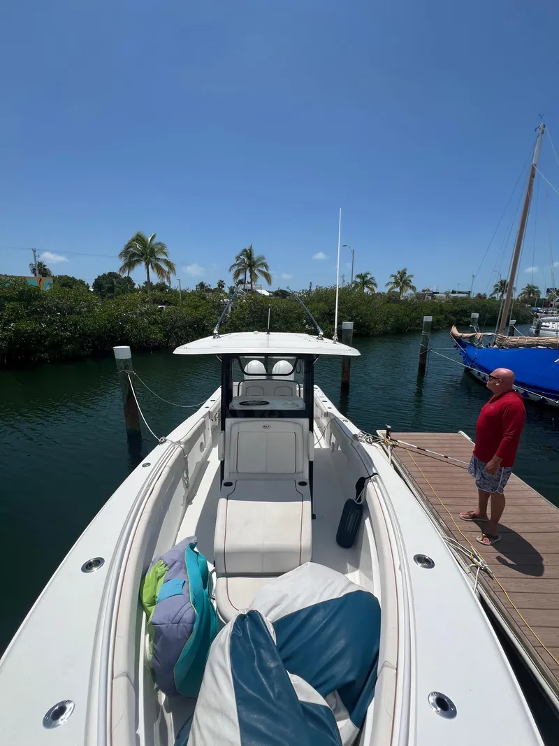 Slide: The Image of 2022 Sea Hunt Gamefish 30 Coffin Box boat docked, featuring dual engines and spacious seating. - 18