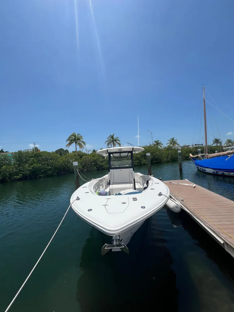 Slide: The Image of 2022 Sea Hunt Gamefish 30 Coffin Box boat docked, surrounded by other boats, under a clear sky. - 2