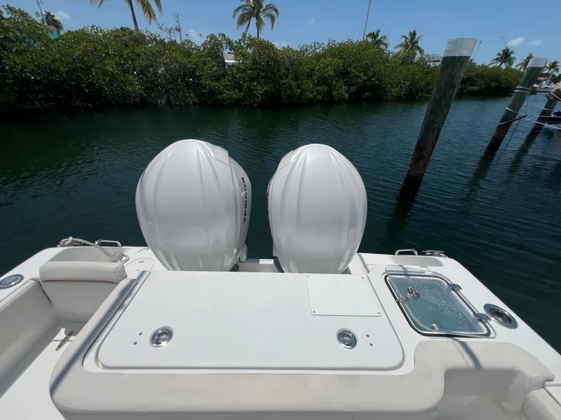 Slide: The Image of 2022 Sea Hunt Gamefish 30 Coffin Box boat with open storage, docked under blue sky. - 24