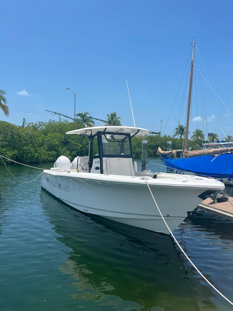 Slide: The Image of 2022 Sea Hunt Gamefish 30 Coffin Box boat docked at marina under blue sky. - 3