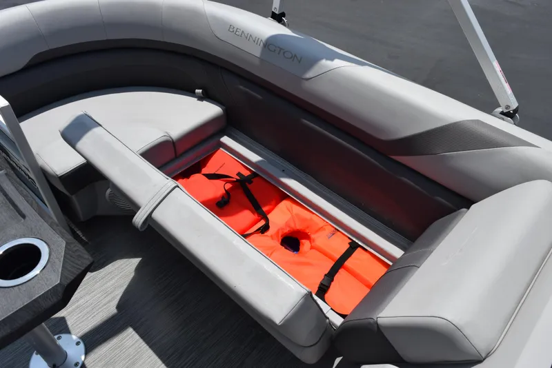 Slide: The Image of 2022 Bennington SX 23 Stern Lounge with gray seating and orange life jackets stored underneath. - 16
