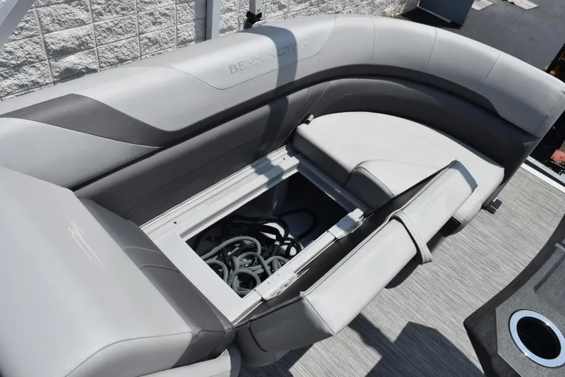 Slide: The Image of 2022 Bennington SX 23 Stern Lounge with open storage compartment, showcasing sleek gray seating. - 17
