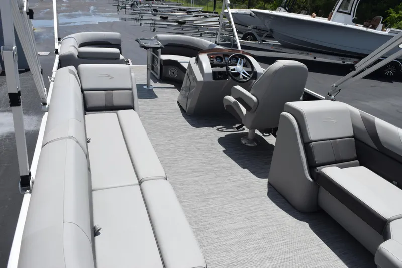 Slide: The Image of 2022 Bennington SX 23 Stern Lounge pontoon boat interior with gray seating and helm. - 8