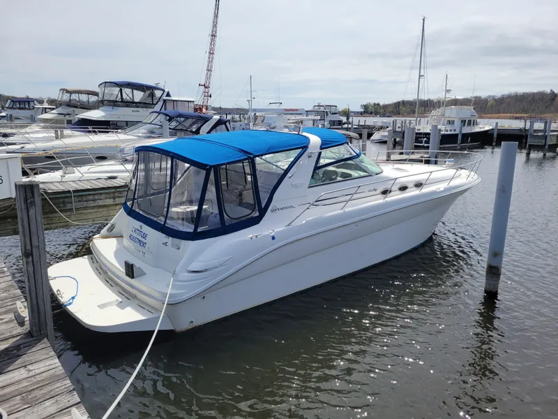 Slide: The Image of 1995 Sea Ray 370 Sundancer docked at marina with blue canopy. - 1