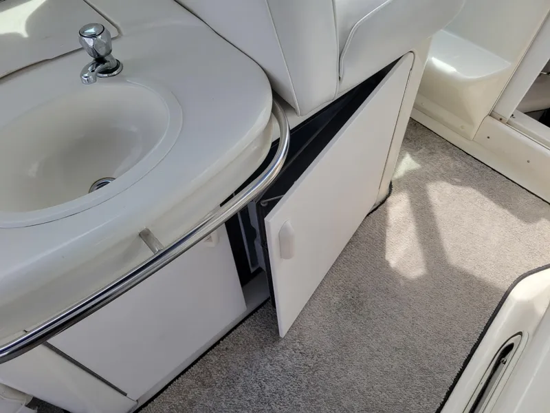 Slide: The Image of 1995 Sea Ray 370 Sundancer interior with sink and open storage cabinet. - 13