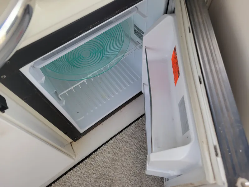 Slide: The Image of Open refrigerator on 1995 Sea Ray 370 Sundancer boat, showing empty interior with glass plate. - 14