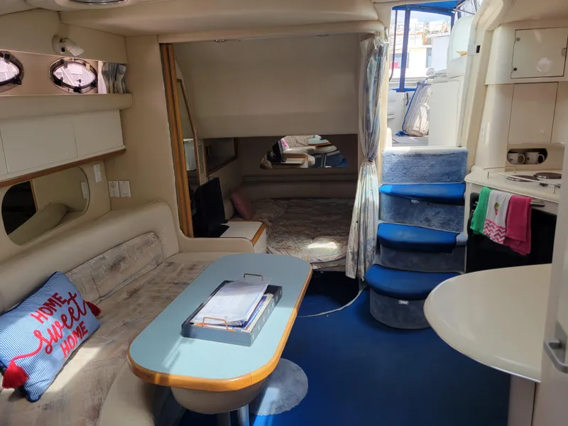 Slide: The Image of Interior of a 1995 Sea Ray 370 Sundancer yacht, featuring cozy seating and nautical decor. - 15