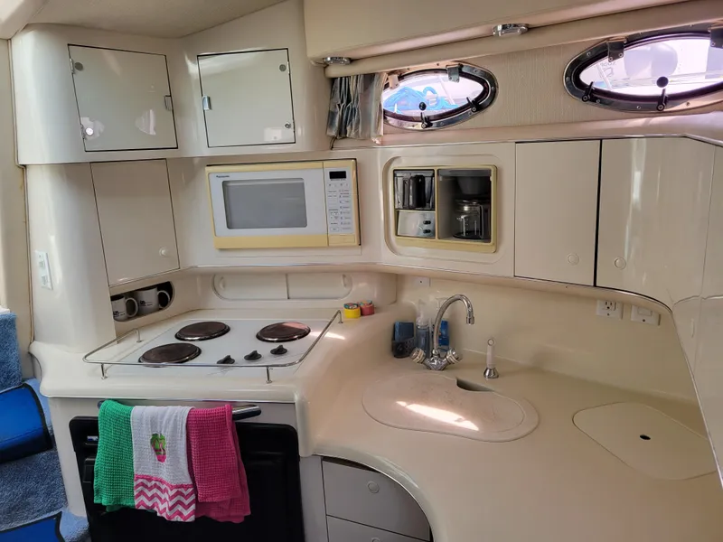 Slide: The Image of 1995 Sea Ray 370 Sundancer kitchen with stove, microwave, and sink. - 19
