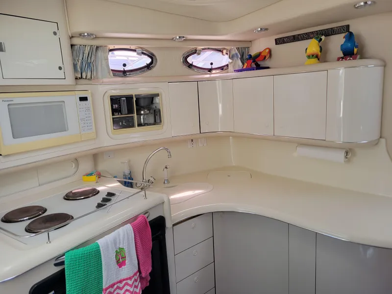 Slide: The Image of 1995 Sea Ray 370 Sundancer kitchen with stove, microwave, and colorful decor. - 20