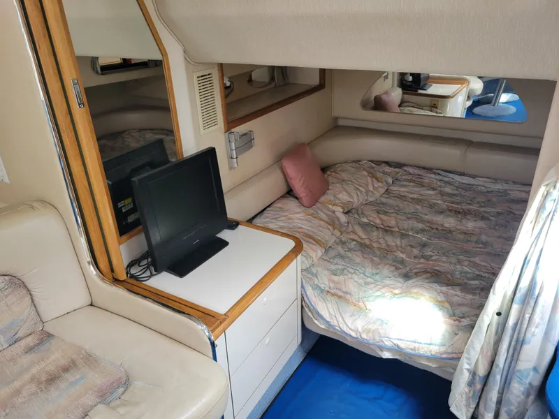 Slide: The Image of 1995 Sea Ray 370 Sundancer cabin with bed, TV, and seating area. - 23
