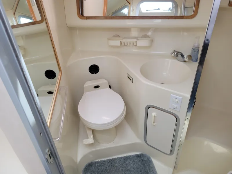 Slide: The Image of 1995 Sea Ray 370 Sundancer bathroom with toilet, sink, and mirror. - 28