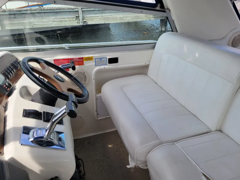 Slide: The Image of 1995 Sea Ray 370 Sundancer helm with white seating and steering wheel. - 6