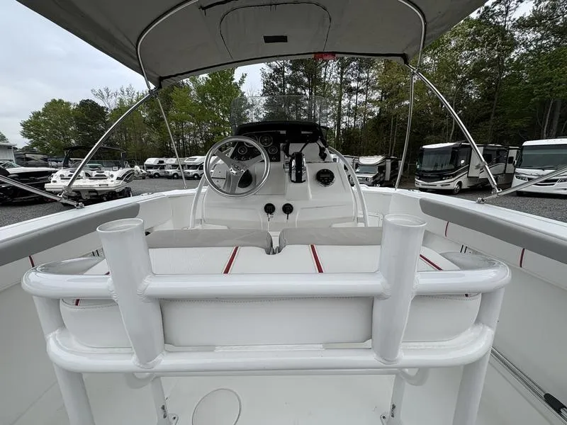Slide: The Image of 2020 Tahoe 2150 boat interior with steering wheel, seating, and canopy in a marina setting. - 11