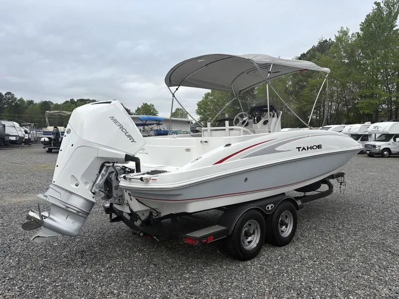 Slide: The Image of 2020 Tahoe 2150 boat with Mercury outboard engine on a trailer in a parking lot. - 3
