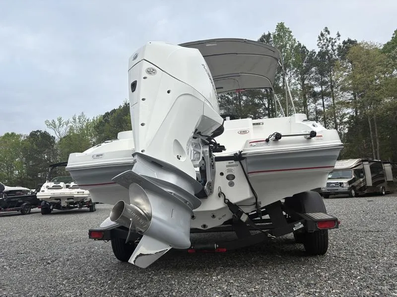 Slide: The Image of 2020 Tahoe 2150 boat with outboard motor on trailer, parked outdoors. - 5