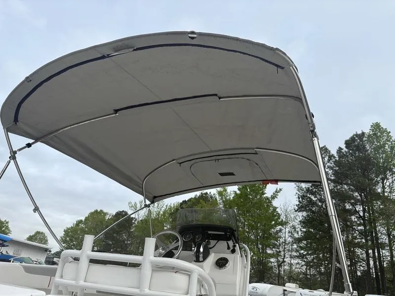 Slide: The Image of 2020 Tahoe 2150 boat with canopy, steering wheel, and dashboard, set against a forested background. - 9