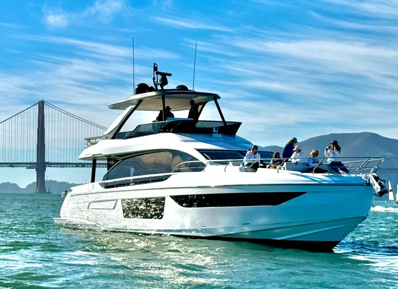 Slide: The Image of Azimut Fly 68 yacht cruising near a bridge, 2024 model, with people on deck. - 2
