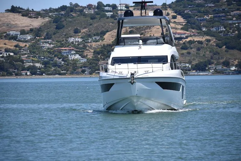 Slide: The Image of 2024 Azimut Fly 68 yacht cruising on a serene lake with scenic hillside backdrop. - 21
