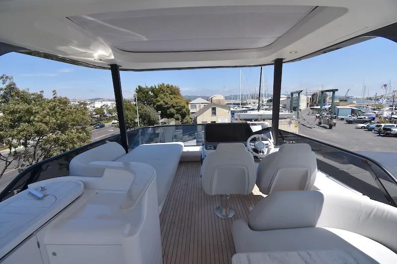 Slide: The Image of Flybridge of 2024 Azimut Fly 68 yacht with luxurious seating and helm, docked at marina. - 24