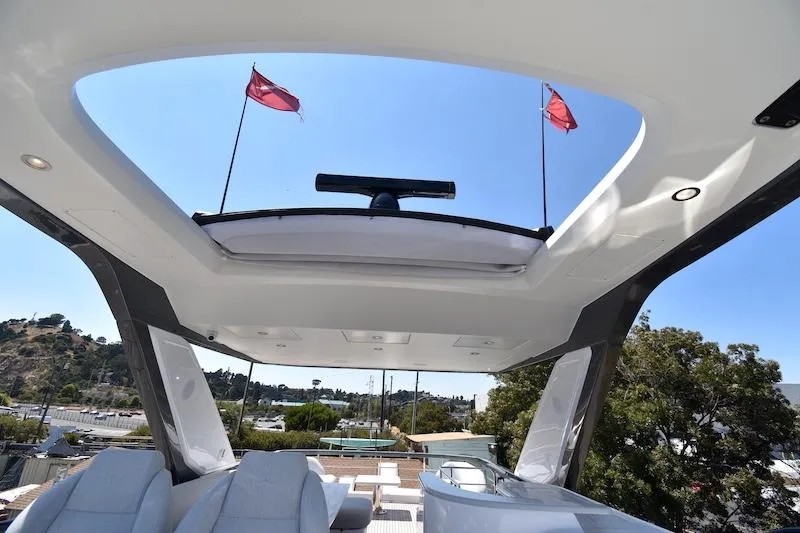 Slide: The Image of 2024 Azimut Fly 68 yacht with open sunroof and flags, showcasing luxury design. - 27