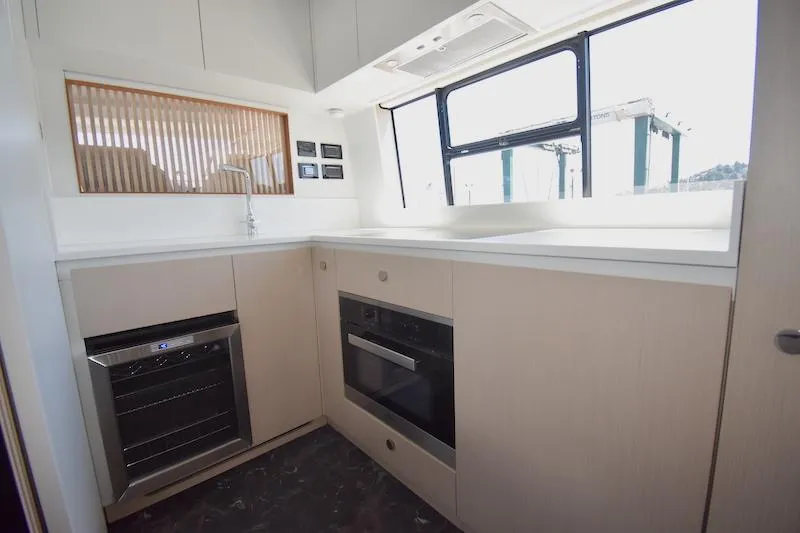 Slide: The Image of Modern kitchen interior of 2024 Azimut Fly 68 yacht with sleek appliances and ample natural light. - 9