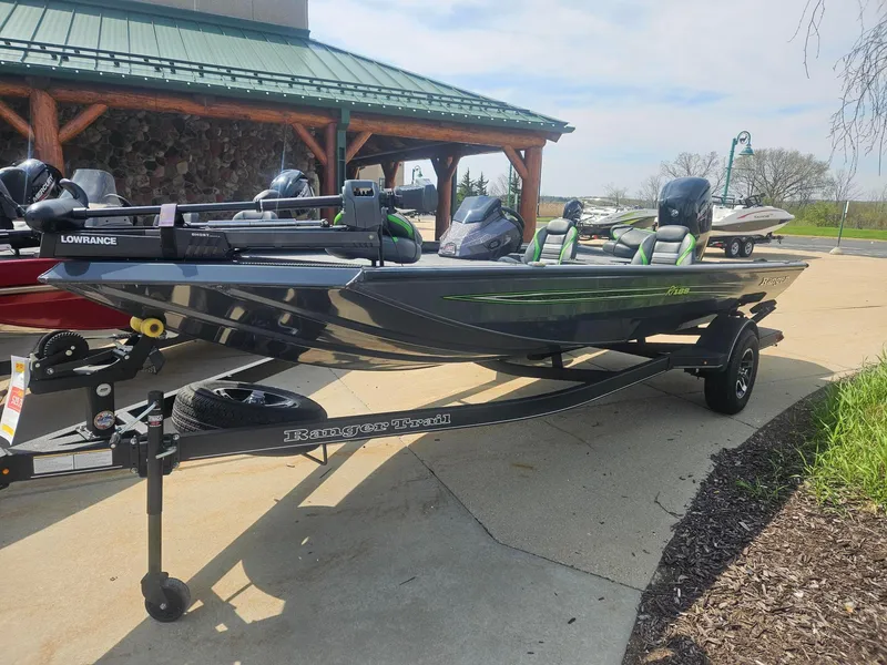 Slide: The Image of 2023 Ranger RT188 fishing boat on trailer, parked outdoors near a wooden building. - 1