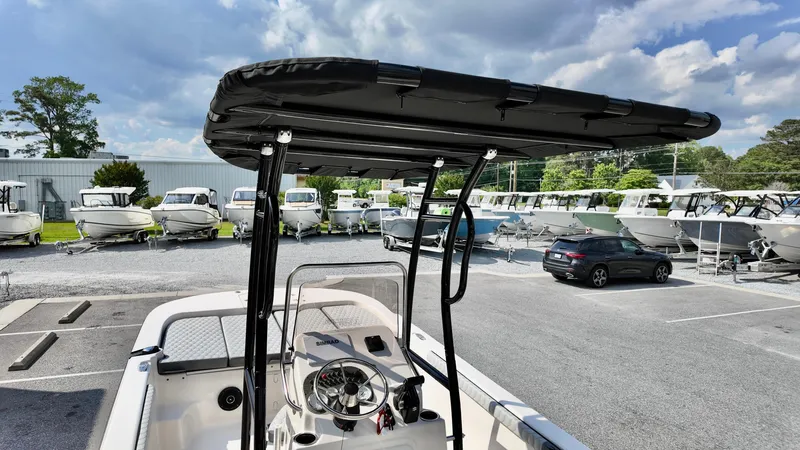 Slide: The Image of 2025 Carolina Skiff 21 LS Stealth Edition boat with T-top, parked in a marina. - 14