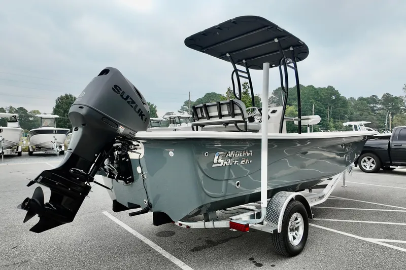 Slide: The Image of 2026 Carolina Skiff 21 LS Stealth Edition boat with Suzuki outboard motor on trailer. - 2