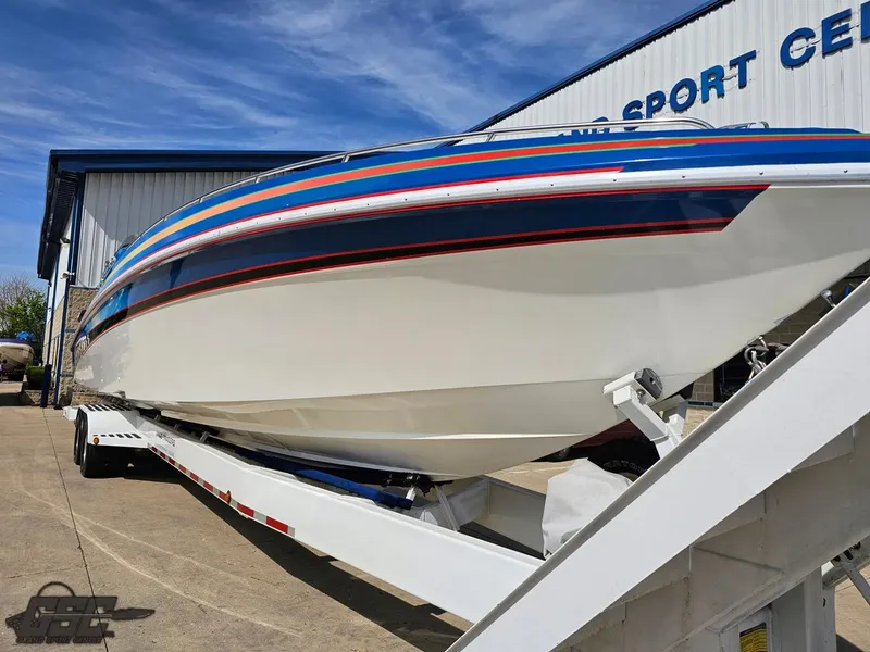 Slide: The Image of 2002 Black Thunder 460 SC boat on trailer, vibrant stripes, outside a sports center. - 13