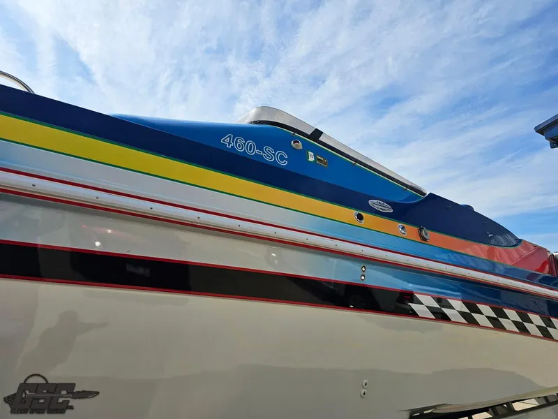 Slide: The Image of 2002 Black Thunder 460 SC boat with colorful stripes under a blue sky. - 18