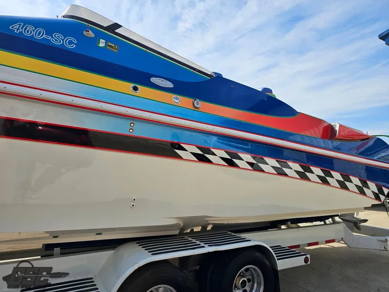 Slide: The Image of 2002 Black Thunder 460 SC boat with colorful stripes on a trailer. - 19
