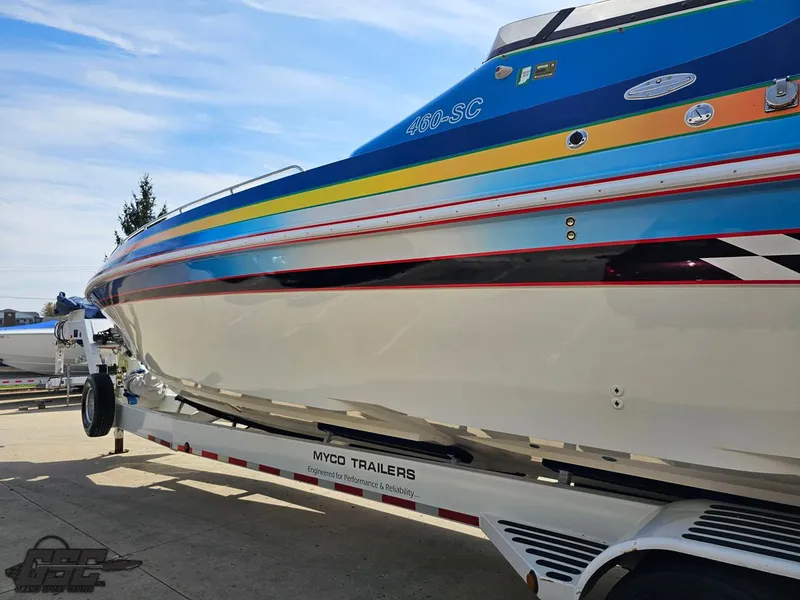 Slide: The Image of 2002 Black Thunder 460 SC boat on trailer, vibrant stripes, sunny day. - 21