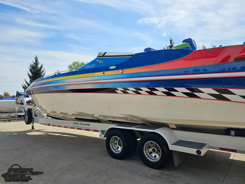 Slide: The Image of 2002 Black Thunder 460 SC boat on trailer, vibrant colors, parked outdoors. - 23