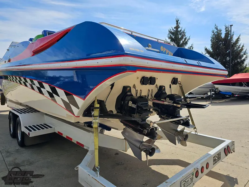 Slide: The Image of 2002 Black Thunder 460 SC boat on trailer, featuring dual engines and vibrant blue design. - 25