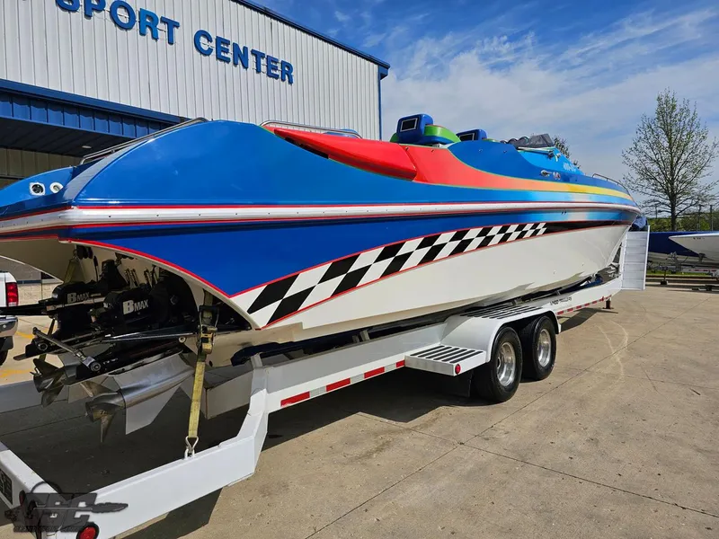 Slide: The Image of 2002 Black Thunder 460 SC speedboat with vibrant colors on a trailer at a sport center. - 32