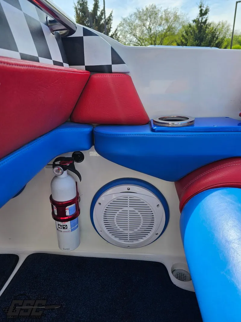 Slide: The Image of Interior of 2002 Black Thunder 460 SC boat with vibrant red and blue seating. - 48